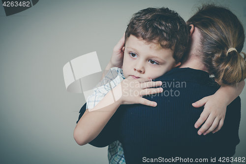 Image of sad son hugging his mother