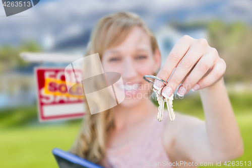 Image of Excited Woman Holding House Keys and Sold Real Estate Sign in Fr