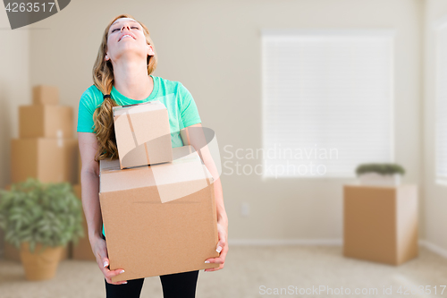 Image of Tired Young Adult Woman Holding Moving Boxes In Empty Room In A 