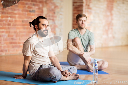 Image of men resting on mats at yoga studio