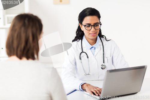 Image of doctor with laptop and woman patient at hospital