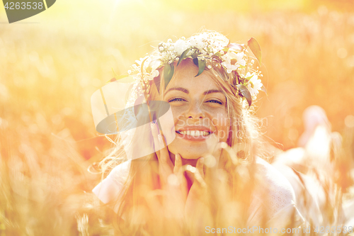 Image of happy woman in wreath of flowers on cereal field