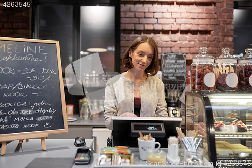 Image of happy woman or barmaid with cashbox at cafe