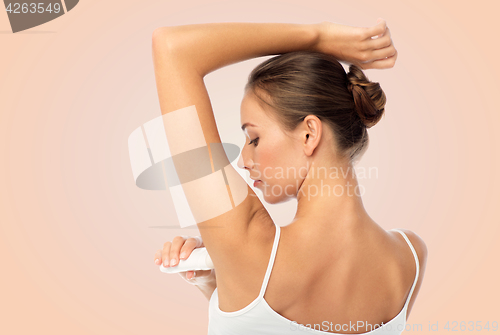 Image of woman with antiperspirant deodorant over white