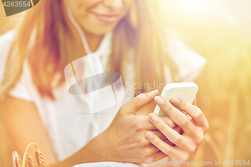 Image of close up of woman with smartphone and earphones