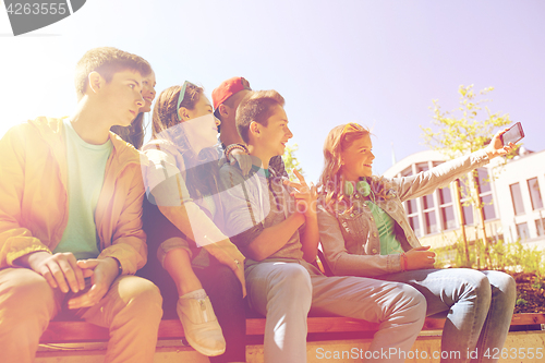 Image of happy teenage students taking selfie by smartphone
