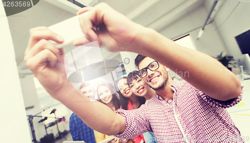 Image of creative business team taking selfie at office