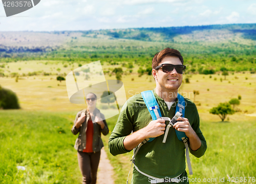 Image of happy couple with backpacks traveling in africa