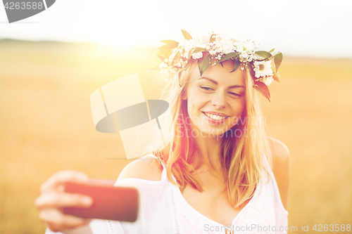 Image of happy young woman taking selfie by smartphone