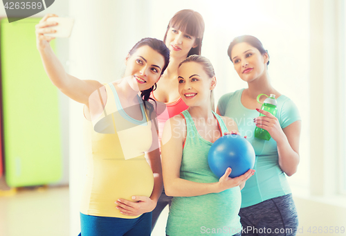 Image of pregnant women taking selfie by smartphone in gym