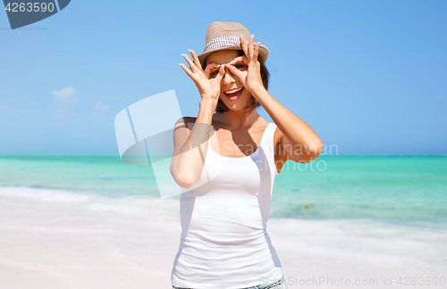 Image of happy young woman in hat on summer beach
