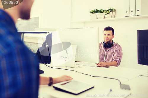 Image of creative man with headphones and computer