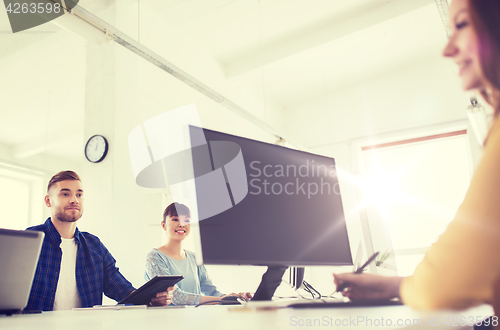 Image of happy creative team with computers at office