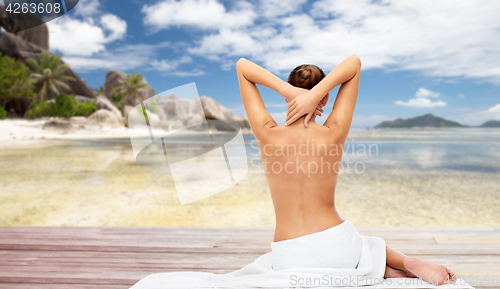 Image of beautiful woman in towel with bare top on beach