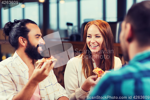 Image of friends eating pizza with beer at restaurant