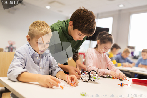 Image of happy children building robots at robotics school