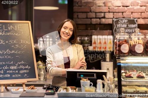 Image of happy woman or barmaid at cafe counter