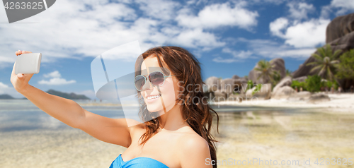 Image of woman in swimsuit taking selfie with smatphone