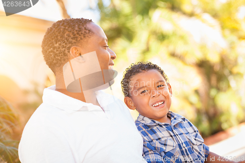 Image of Mixed Race Son and African American Father Playing Outdoors Toge