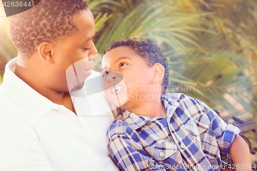 Image of Mixed Race Son and African American Father Playing Outdoors Toge