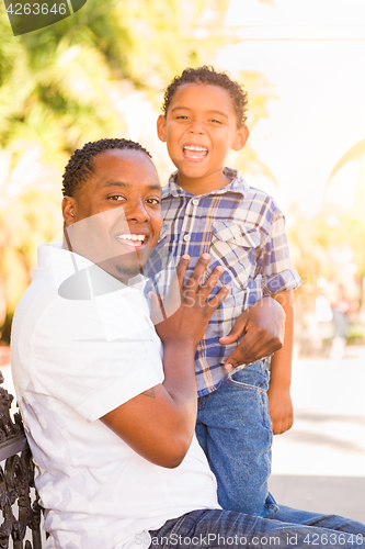 Image of Mixed Race Son and African American Father Playing Outdoors Toge