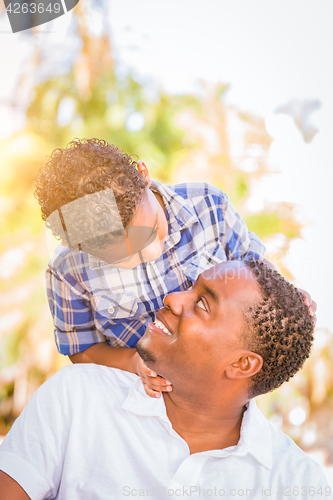 Image of Mixed Race Son and African American Father Playing Outdoors Toge