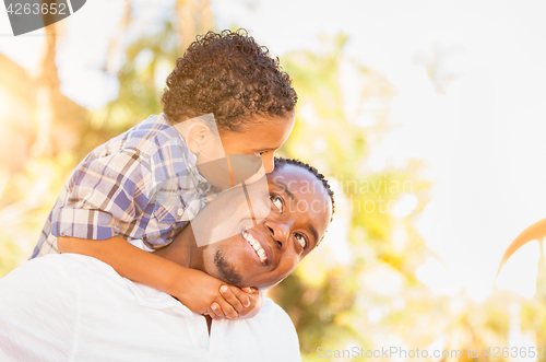 Image of Mixed Race Son and African American Father Playing Outdoors Toge