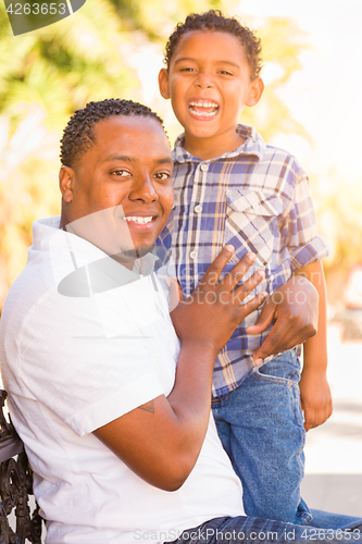 Image of Mixed Race Son and African American Father Playing Outdoors Toge