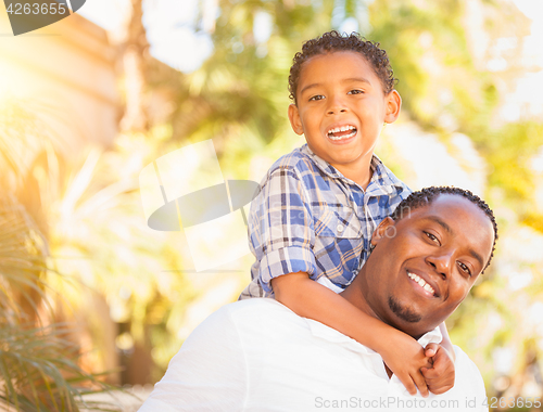 Image of Mixed Race Son and African American Father Playing Outdoors Toge