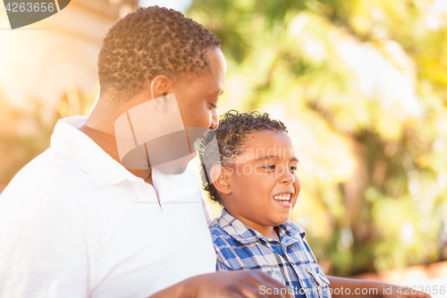 Image of Mixed Race Son and African American Father Playing Outdoors Toge