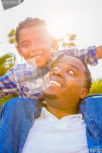 Image of Mixed Race Son and African American Father Playing Piggyback Out