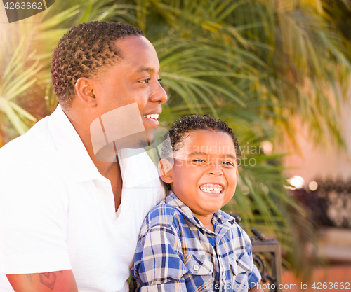 Image of Mixed Race Son and African American Father Playing Outdoors Toge