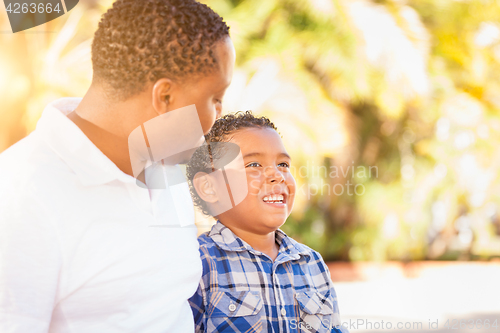 Image of Mixed Race Son and African American Father Playing Outdoors Toge