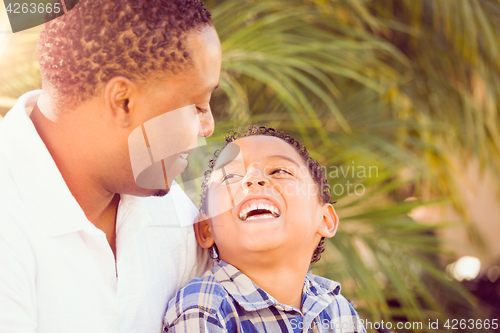 Image of Mixed Race Son and African American Father Playing Outdoors Toge