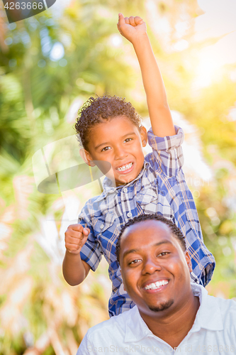 Image of Mixed Race Son and African American Father Playing Outdoors Toge