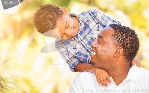 Image of Mixed Race Son and African American Father Playing Outdoors Toge