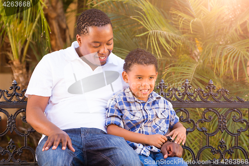 Image of Mixed Race Son and African American Father Playing Outdoors Toge