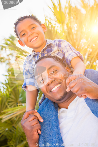 Image of Mixed Race Son and African American Father Playing Piggyback Out