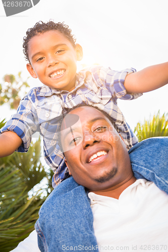Image of Mixed Race Son and African American Father Playing Piggyback Out