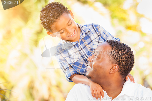 Image of Mixed Race Son and African American Father Playing Outdoors Toge