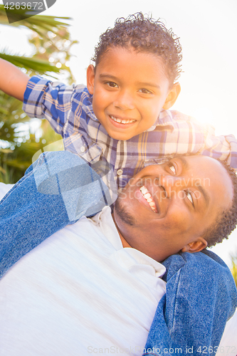 Image of Mixed Race Son and African American Father Playing Piggyback Out
