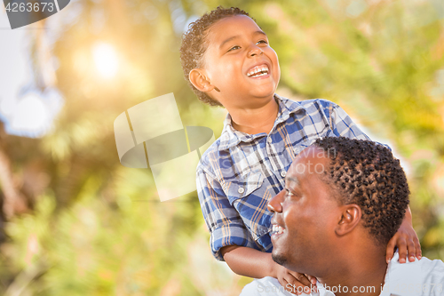 Image of Mixed Race Son and African American Father Playing Outdoors Toge