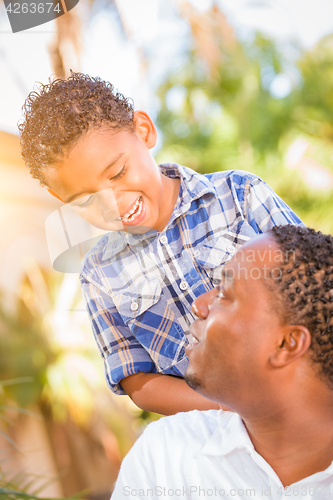 Image of Mixed Race Son and African American Father Playing Outdoors Toge