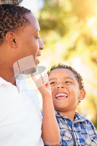 Image of Mixed Race Son and African American Father Playing Outdoors Toge