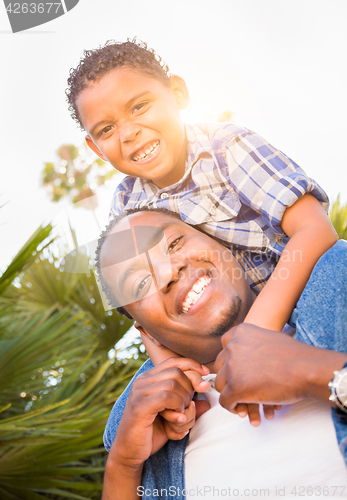 Image of Mixed Race Son and African American Father Playing Piggyback Out