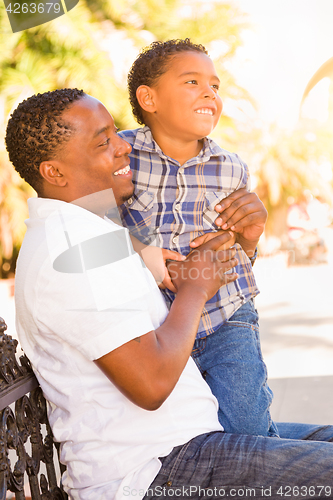 Image of Mixed Race Son and African American Father Playing Outdoors Toge