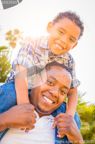 Image of Mixed Race Son and African American Father Playing Piggyback Out