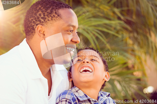 Image of Mixed Race Son and African American Father Playing Outdoors Toge