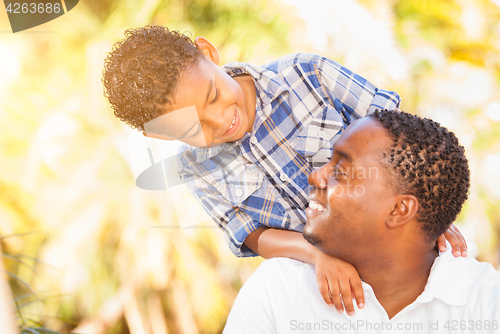 Image of Mixed Race Son and African American Father Playing Outdoors Toge