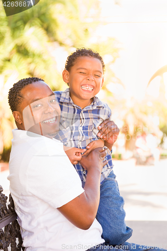 Image of Mixed Race Son and African American Father Playing Outdoors Toge